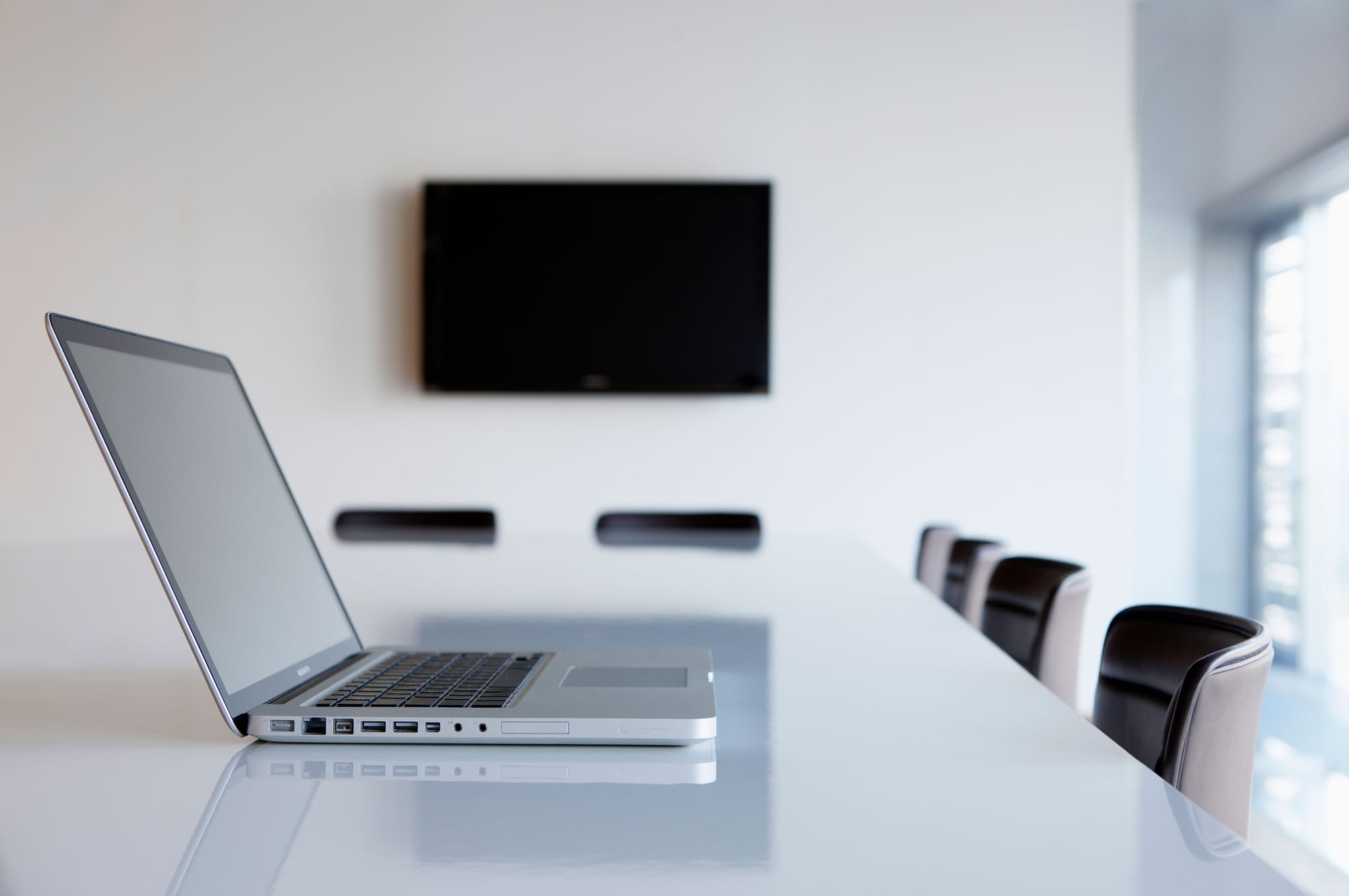A laptop on a boardroom desk